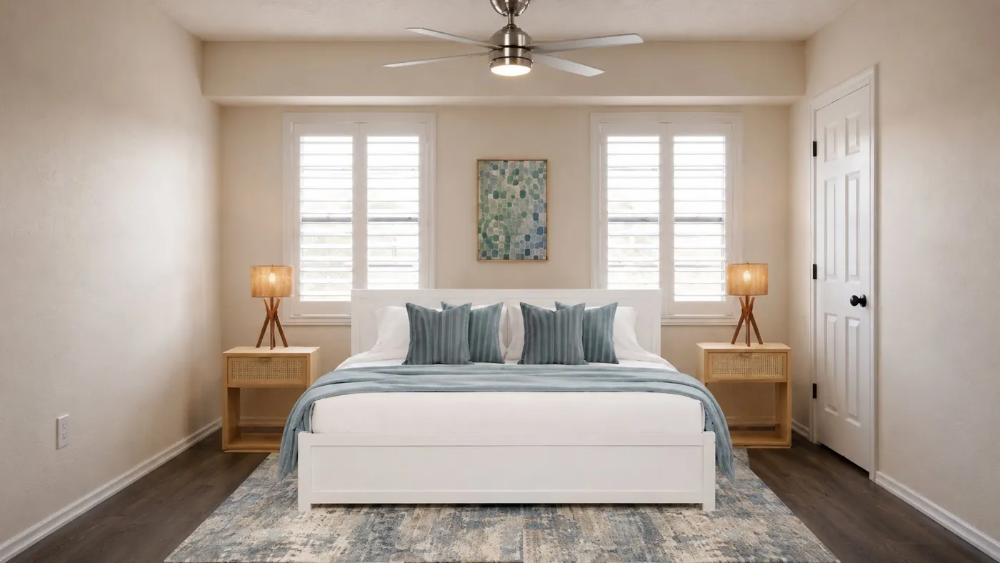 Main bedroom with a white bed, blue cushions and rattan bedside tables
